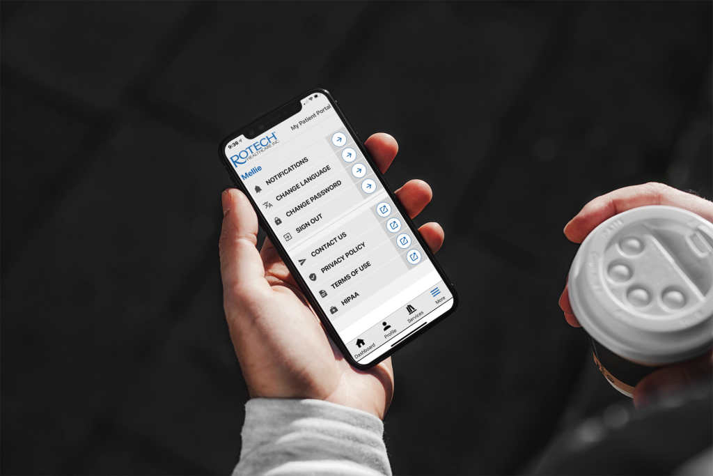 Man with a smartphone showing the Rotech Mobile App in one hand and a coffee in the other