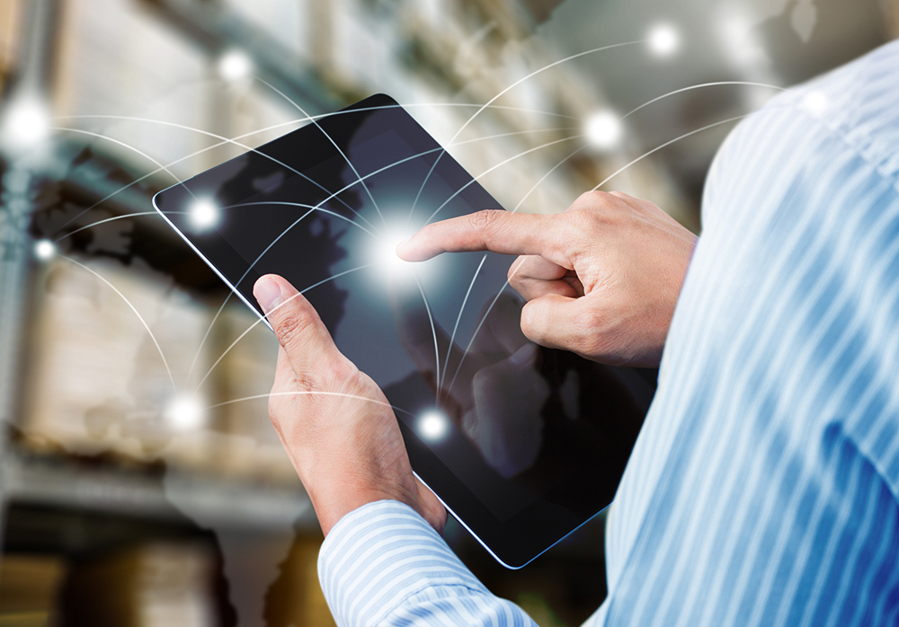 man holding tablet with overlaid conceptual illustration of shipping routes