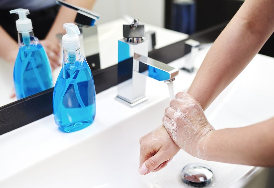 person washing their hands in a sink with soap