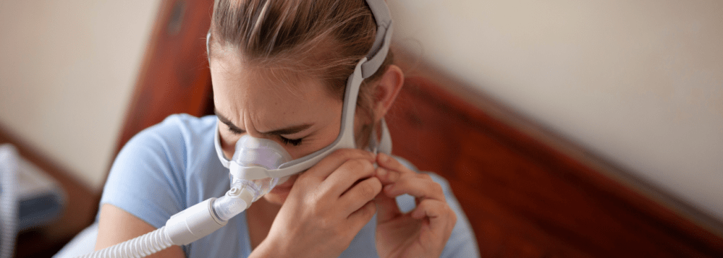 Woman taking off her CPAP nasal mask