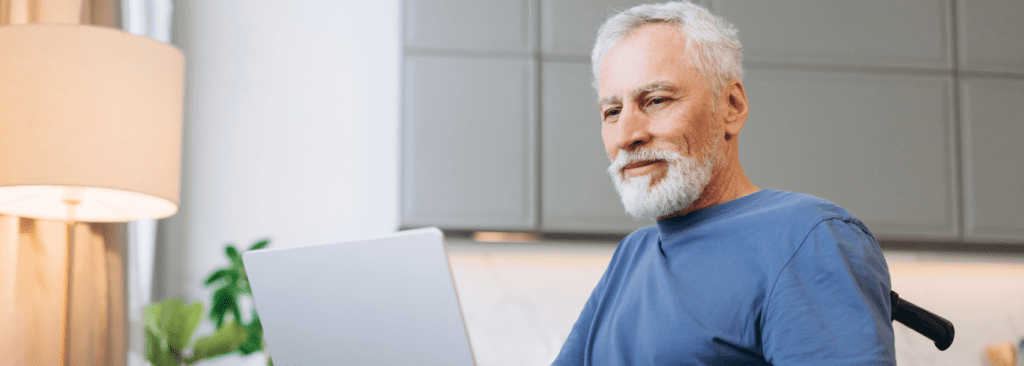Image of senior man in wheelchair looking at his laptop