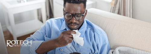 Man coughing with a tissue in front of him
