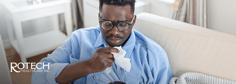 Man coughing with a tissue in front of him