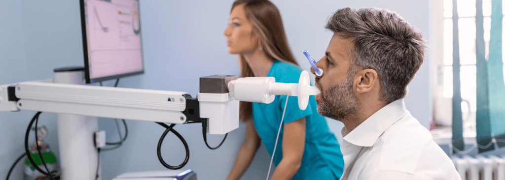 Adult man testing breathing function by spirometry having health problem. Diagnosis of respiratory function in pulmonary disease.