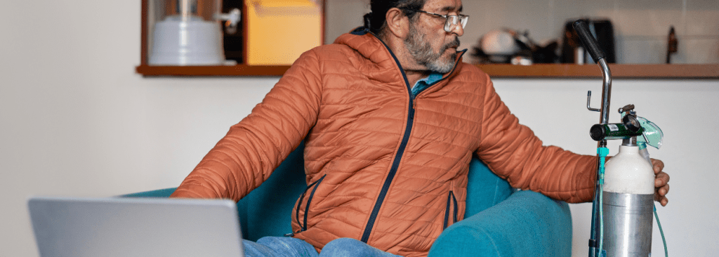 Man sitting in chair and moving his oxygen tank