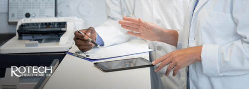 Two medical professionals reviewing patient chart together in the hospital at a desk