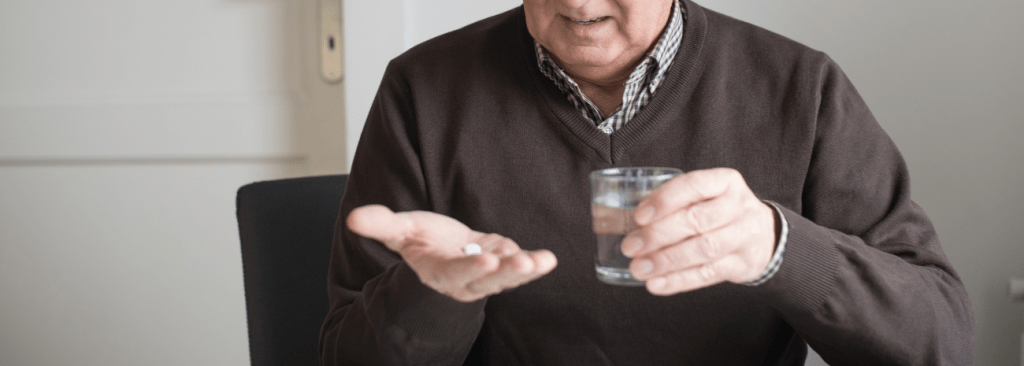 Older man taking his medication at home as prescribed