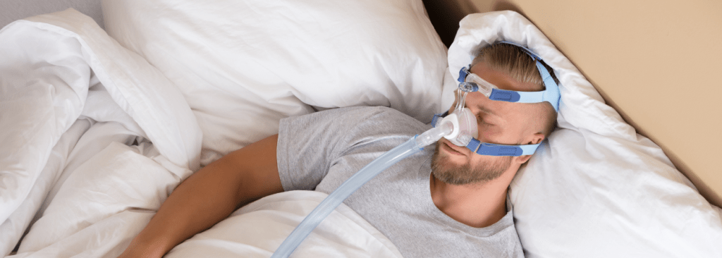 Man sleeping in bed with a CPAP mask on his face