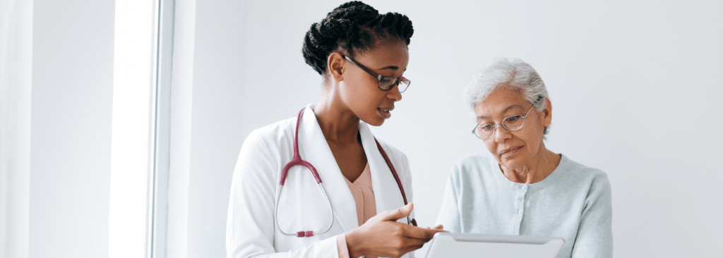 Female doctor reviewing information with female senior patient