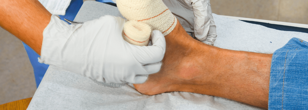 Healthcare professional dressing a person's wound on their foot