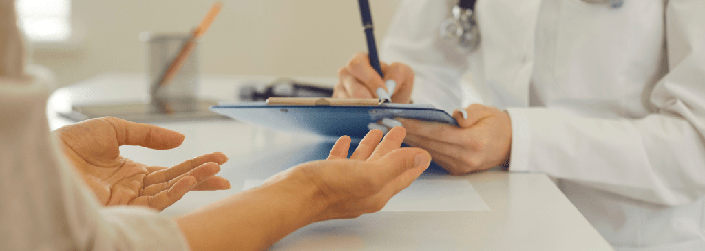 Healthcare professional discharging a patient while writing on clipboard
