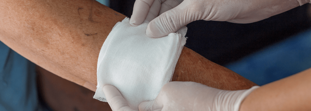 Person getting wound dressed by healthcare professional on their arm