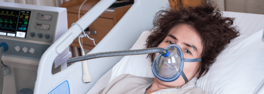 Female patient using ventilator mask at hospital in bed
