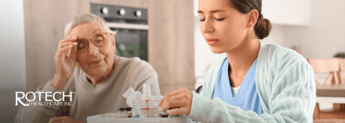 Caregiver helping elderly woman with wound care at home