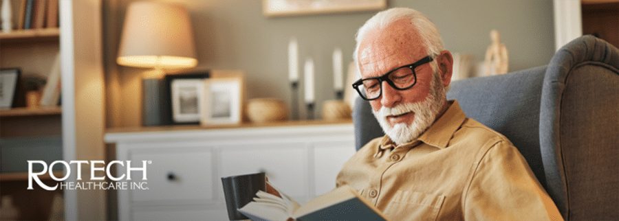 Senior man sitting in chair reading book