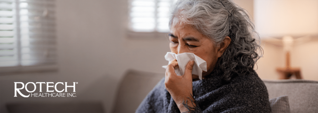 Senior woman on couch blowing her nose with tissue