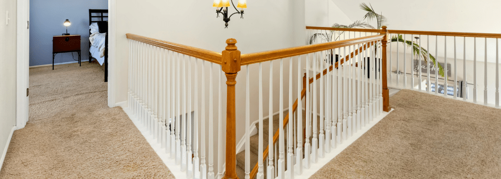 Hallway in home with stairs and bedroom door open